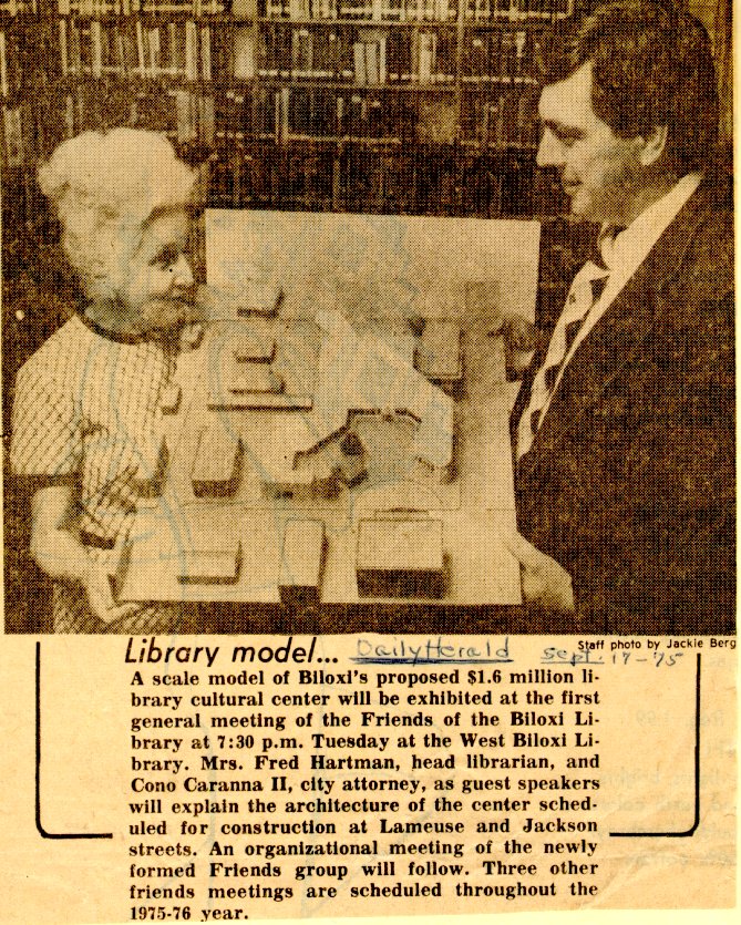 A newspaper clipping titled “A newspaper clipping titled “Library model…” showing two individuals standing beside a scale model of Biloxi’s proposed $1.6 million library cultural center. The article explains that the model was exhibited at the first general meeting of the Friends of the Biloxi Library, with guest speakers discussing the architecture and plans for construction at Lameuse and Jackson streets.
